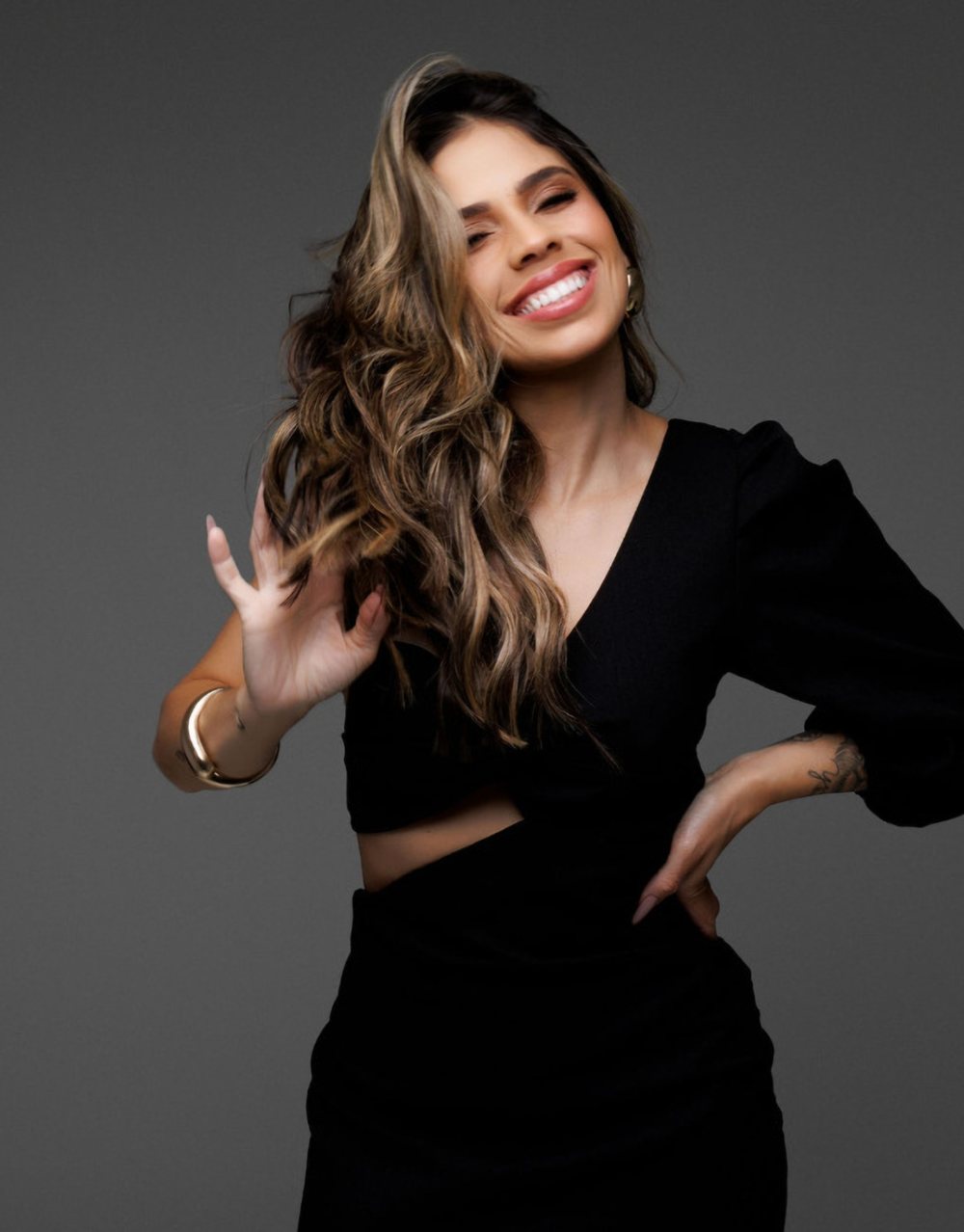 Bruna Kimberlly rindo, com o cabelo em movimento